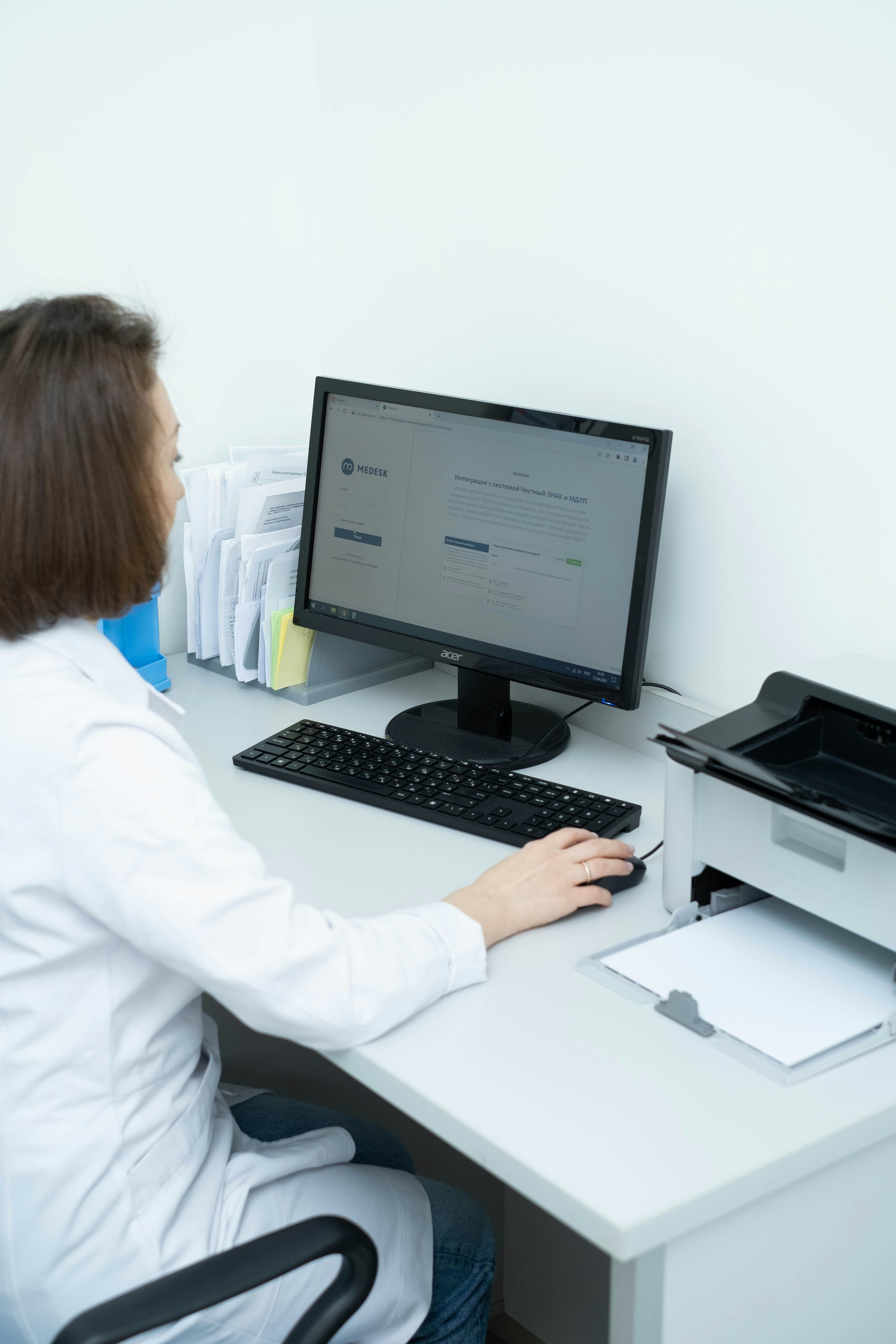 Clinician using clinical documentation software on a desktop monitor